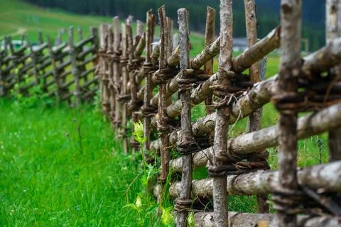 A rustic fence built in an Alpine valley to keep out wild animals from pastur Stock Photos