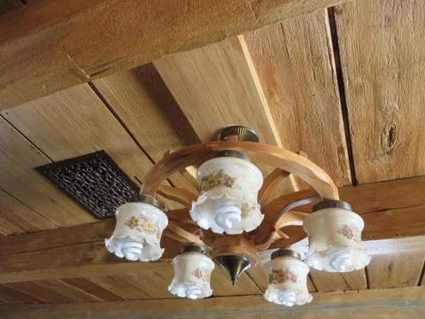 Rustic five globe ceiling light indoors fixed on wooden beam Stock Photos