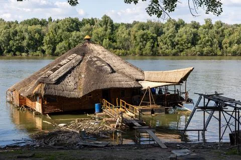 A rustic, floating hut sits peacefully on a riverbank Stock Photos