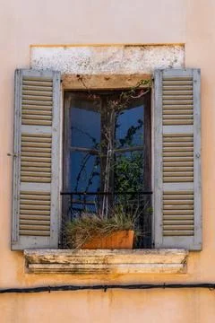 Rustic flower pot with dried grass and flowers sits on windowsill with weathe Foto stock