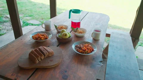 Rustic food on a wooden table. Bread, porridge, fruits, salad, compote Stock Footage 157660327