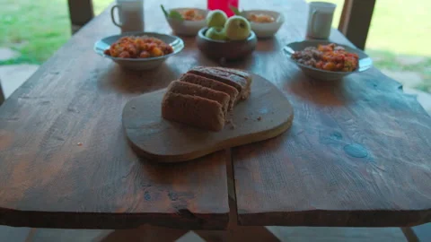 Rustic food on a wooden table. Bread, porridge, fruits, salad, compote Stock Footage 157660382