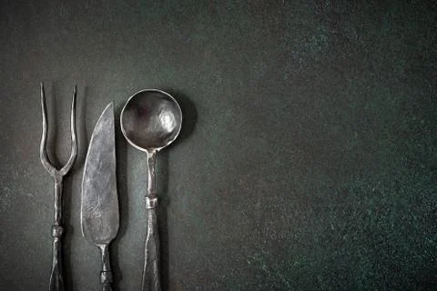 Rustic fork spoon and knife on dark Fotos de archivo