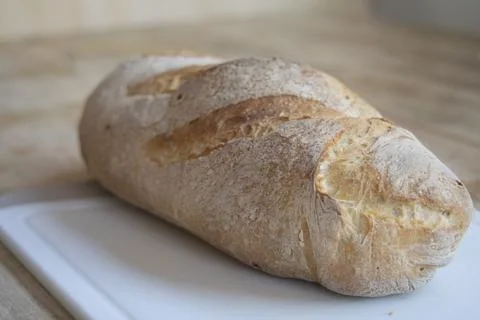 Rustic fresh  loaf made with sourdough on kitchen board for food security c.. Stock Photos