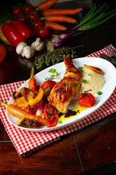 Rustic fried chicken legs with assorted vegetables and rice Stock Photos