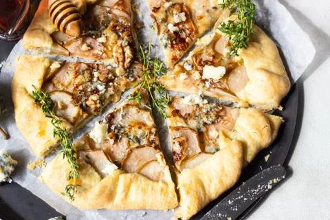 Rustic galette with pears, blue cheese, walnuts and honey. Stock Photos