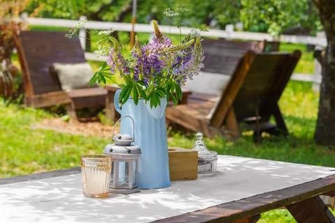 Rustic garden table setting with wildflower bouquet in summer backyard, pat.. Stock Photos