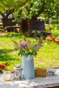 Rustic garden table setting with wildflower bouquet in summer backyard, pat.. Stock Photos