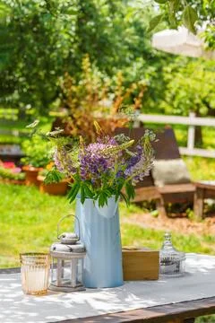 Rustic garden table setting with wildflower bouquet in summer backyard, pat.. 스톡 사진