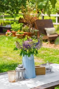 Rustic garden table setting with wildflower bouquet in summer backyard, pat.. Stock Photos