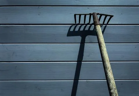 Rustic Garden Tool with Shadow on Painted Wood Background 库存照片