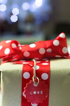 Rustic gift with red bow and christmas lights Stock Photos