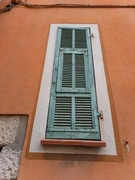 Rustic green shutters on orange facade in Villefranche sur Mer Fotos de archivo
