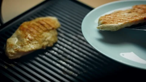 Rustic grill ridges searing a tender piece of poultry in warm light, 4K Vidéo 341111896