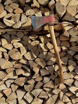 Rustic Hand Axe Against Stacked Firewood Background Stock Photos
