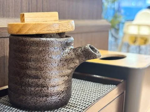 Rustic Handmade Ceramic Soy Sauce Dispenser with Wooden Lid on Restaurant Table Stock Photos