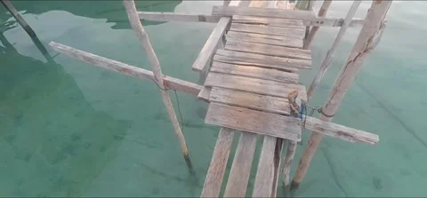 A rustic, handmade wooden footbridge built over crystal-clear turquoise sea  Video stock 338007937