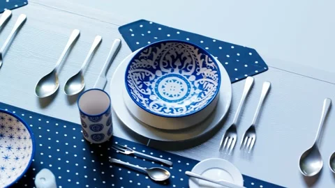 Rustic handpainted tableware. Blue and white plates on a dotted blue tablecloth. Video stock 201223493