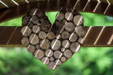 Rustic heart shape crafted from natural wood slices in bright sunlight 스톡 사진