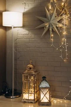 Rustic holiday decor with two lanterns filled with string lights, standing next Stock Photos