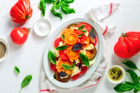 Rustic homemade Italian Caprese salad with torn to pieces mozzarella and vari Stock Photos