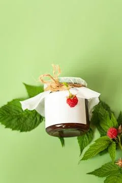 Rustic homemade raspberry jam with green leaves and copy space Stock Photos