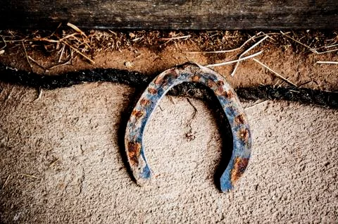 Rustic horseshoe on barn floor Stock Photos