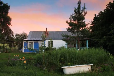 Rustic house on the background of a beautiful sunset Stock Photos