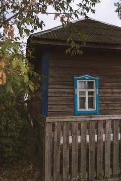 Rustic house with blue windows in the evening in the village Stock Photos