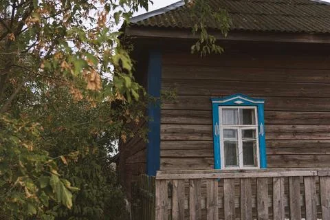 Rustic house with blue windows in the evening in the village Stock Photos