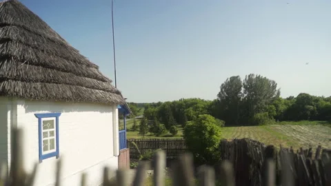 A rustic house with a chimney and white walls, standing next to a forest. Stock Footage 231731725
