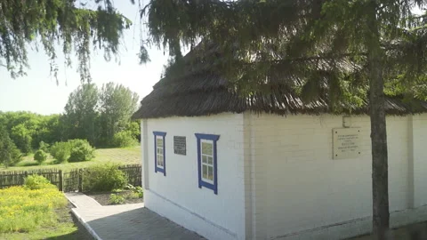 A rustic house with a chimney and white walls, standing next to a forest. Stock Footage 231753893