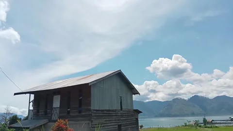 Rustic House by a Serene Lake with Mountain View Stock Footage 292808172