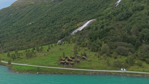 Rustic huts at Lake Lovatnet backed by majestic mountains, Norway Stock Footage 320995292