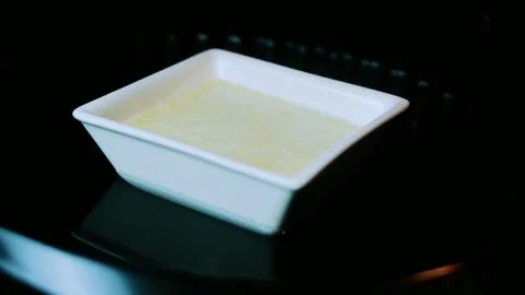 Rustic ingredient study of custard dish positioned inside a dark oven Foto stock