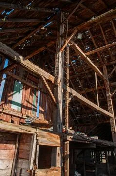 The rustic interior and exposed beams of a large barn. Stock Photos