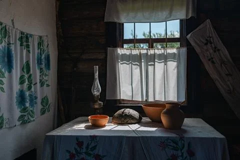 Rustic interior with a window bathed in sunlight. The room is dimly lit, but  Stock Photos
