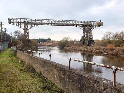 Rustic iron bridge spanning over a calm river on a cloudy day. Warrington t.. 스톡 사진