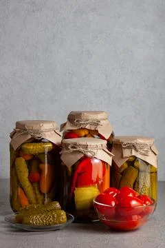 Rustic Jars of Pickled Vegetables with Bowl of Tomatoes. Copy space Stock Photos