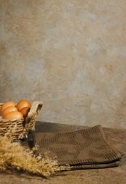 Rustic Kitchen Composition With Brown Eggs in Woven Basket and Folded Towels on  Stock Photos