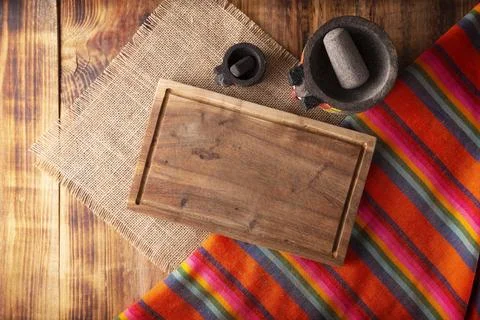 Rustic kitchen concept background. Stone molcajetes and cutting board on rust Stock Photos