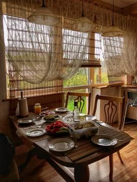Rustic kitchen interior with a wooden table set for a family meal. Stock Photos