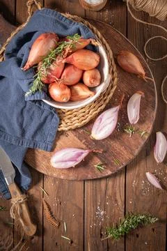 Rustic kitchen setup with fresh shallots in a bowl on a wooden surface, gar.. Stock Photos