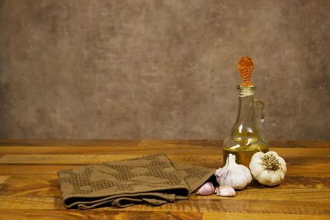 Rustic Kitchen Still Life With Garlic, Olive Oil Bottle and Brown Towel on Woode Stock Photos