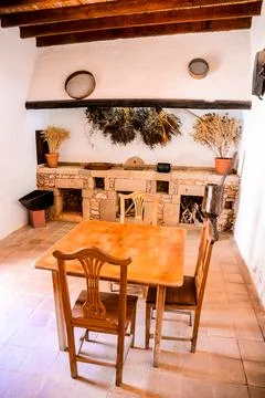 A rustic kitchen with a wooden table and chairs Stock Photos