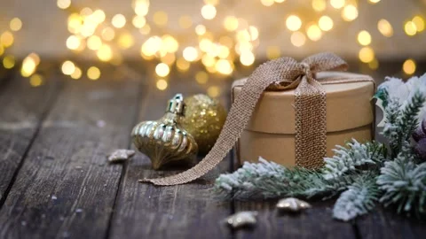 Rustic Kraft Gift Box with Burlap Bow on Wood and Twinkling Lights Stock Footage 343755732
