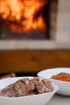 Rustic Lamb Preparation Over Fireplace: Raw Meat Bowls, Warm Hearth, Stone Stock Photos