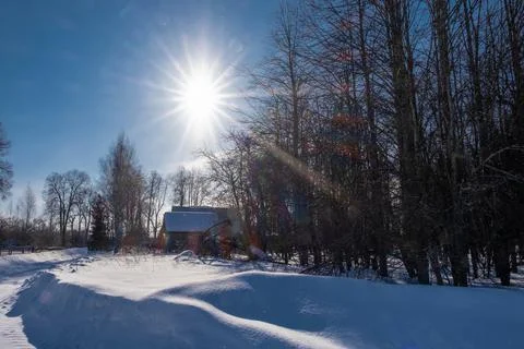 A rustic landscape with a bright sun on a blue sky on a winter day. Stock Photos