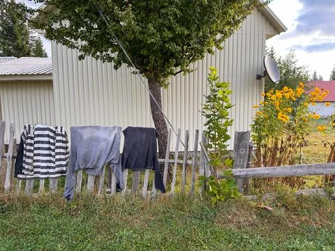 Rustic landscape: long sleeve T-shirts drying right on the fence Stock Photos