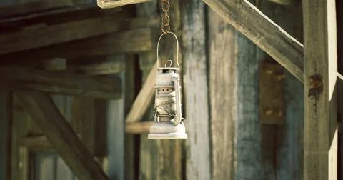 Rustic lantern hanging on wooden structure in an old building Ilustración de archivo